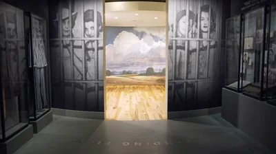 A museum gallery showing many who were imprisoned for their faith. Doors open to a room with depictions of Paradise.