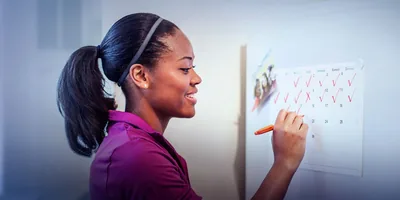 A woman makes marks on a calendar