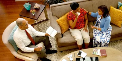 A couple comforts a woman using the Bible