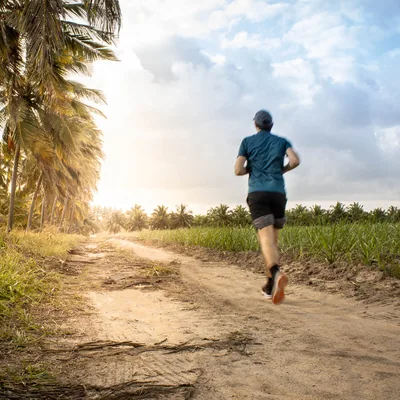 A man jogging down a dirt road.
