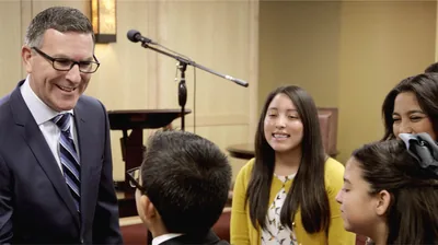A scene from the video ‘Those Whom Jehovah Loves He Disciplines.’ Later in life, Canon talks with young people at a congregation meeting.