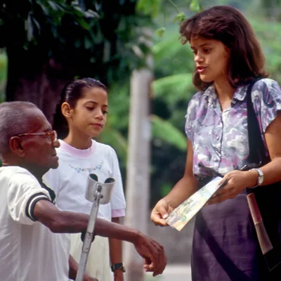 A sister preaching to an older man who is disabled and a young girl.