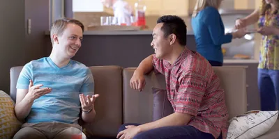 Two young men speak with one another