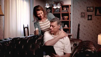 A scene from the video “For a Happy Marriage: Show Respect.” A sister bringing her husband a beverage while he reads on the sofa.