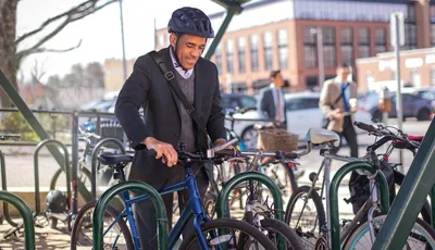 A man parking his bicycle after commuting to work.