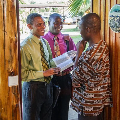 Two brothers in the door-to-door ministry share a scripture with a man