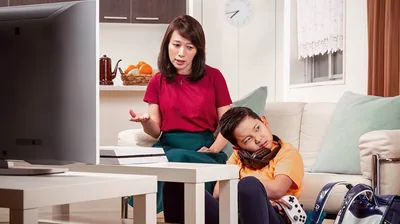 A mother calmly reasons with her son because he has played video games instead of doing chores and schoolwork