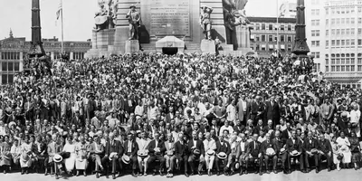A large group of brothers and sisters posing for a photo outdoors at the 1925 convention in Indianapolis, Indiana.