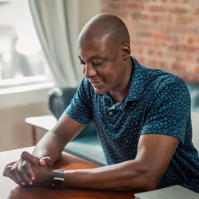 The man is praying before reading the Bible.