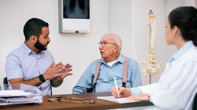 A younger brother helping an elderly brother communicate with a doctor.