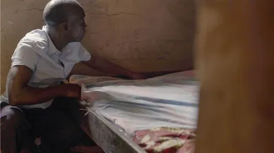 A scene from the video ‘Love Never Fails Despite . . . Poverty—Congo.’ A brother prepares a bed in his home for brothers traveling from afar.