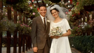 David and Linda Splane smiling while standing in a flower-covered walkway.