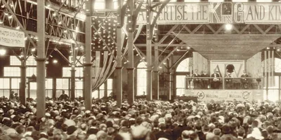 The stage at the 1922 convention. Above the stage is a banner that reads: “Advertise the King and Kingdom.” Behind the stage is a sign with the letters “ADV.”