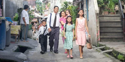 A family of six with limited means walking through a poor neighborhood to meet their brothers for spiritual activities.