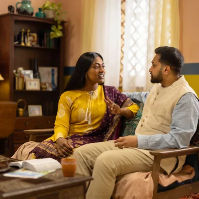 A couple having a discussion in their home. The Bible is open on the table in front of them.