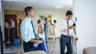 An elder watching a young brother who is texting instead of cleaning the Kingdom Hall.