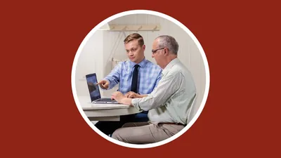 A brother showing his Bible student how to do research on an electronic device.