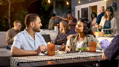 A dating couple enjoying a conversation at a gathering with friends.