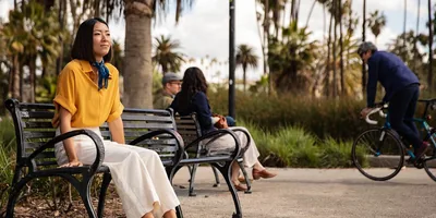 A woman sits on a park bench and ponders
