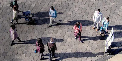 People walk near a public witnessing cart