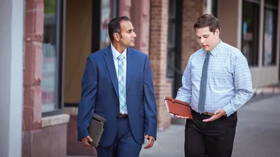 An elder listening intently to a brother express himself as they work together in the field ministry.