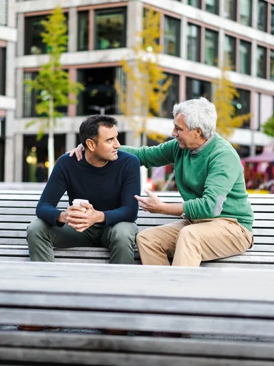 An older man speaks reassuringly to a younger man.