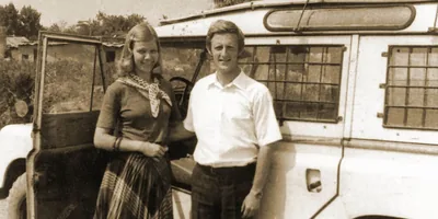 Mats and Ann-Catrin standing next to their SUV in a rural territory.