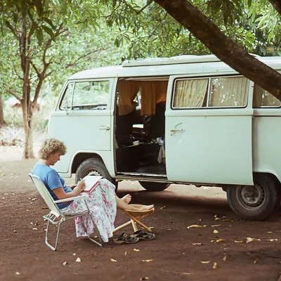 Ann-Catrin sitting on a folding chair outside their Volkswagen Kombi van.