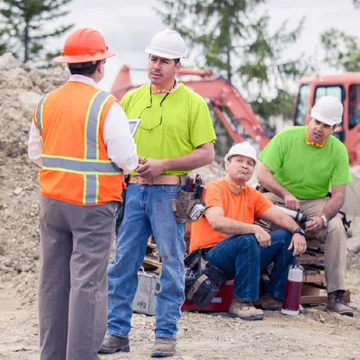 A brother talks to his boss while his coworkers are listening