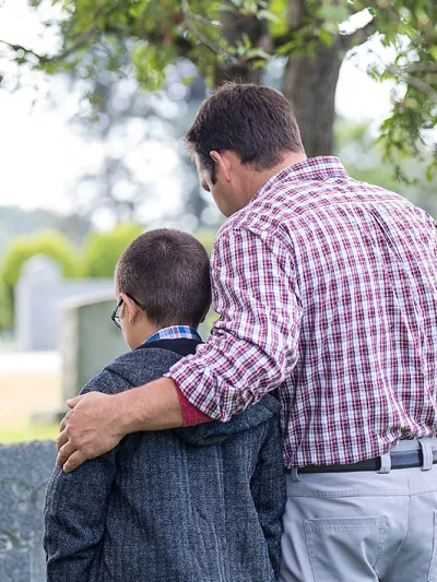 A father and his young son at a cemetery