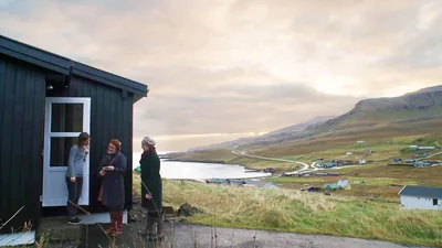 A scene from the video “Preaching in All Weather.” Two sisters preaching to a woman at her doorstep.