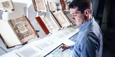A man looks at old Bibles in a museum