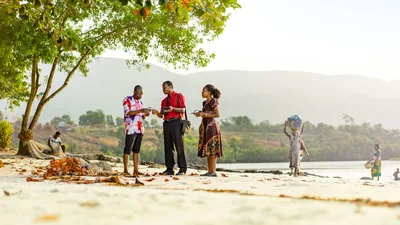 A couple witnessing to a man at a beach.