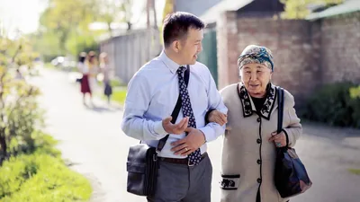 A young elder giving an older sister a supporting arm as they work together in the field ministry.
