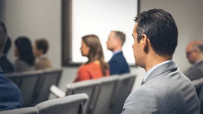 A brother observing a couple who are sitting together at a congregation meeting.