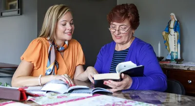 One of Jehovah’s Witnesses studies the Bible with a woman who has a shrine to Mary in her home