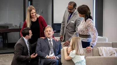 Brothers and sisters at the Kingdom Hall, comforting an older brother who is sad.
