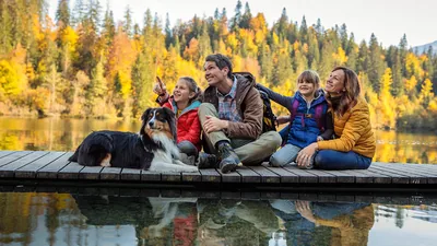 Parents with their two children sitting on a dock and admiring the scenery around them.