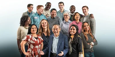 A group of people of different ages and from different racial backgrounds smiling.