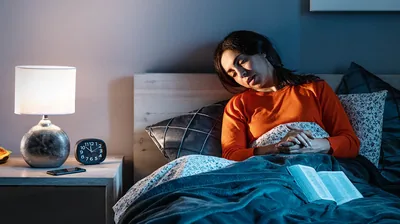 A sister, in bed, falling asleep while she prays.
