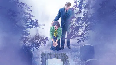 A couple at a cemetery, weeping as they look at a coffin that has been lowered into a grave.