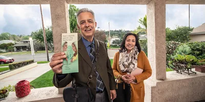 A brother and sister presenting a tract to someone through a doorbell camera.