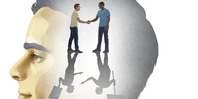 A man imagining himself shaking hands with a man of a different race. Their shadows depict them holding protest signs and arguing with each other.