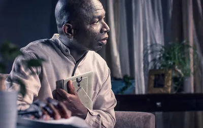 A distressed brother holding to his chest a framed picture.