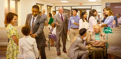 Brothers and sisters converse happily before a congregation meeting.