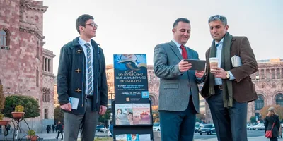 Jehovah’s Witnesses preach to a man beside a public witnessing cart