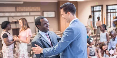 Witnesses of different races greet one another at a Kingdom Hall