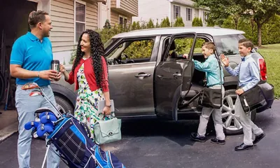 Before a sister leaves with her two boys for field service, she says goodbye to her husband who is ready to go play golf