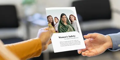 A sister handing a woman a printed copy of the article “Women’s Safety​—The Bible’s Perspective.”