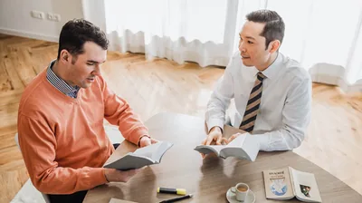The elder using the book “Draw Close to Jehovah” to conduct a Bible study with the brother.